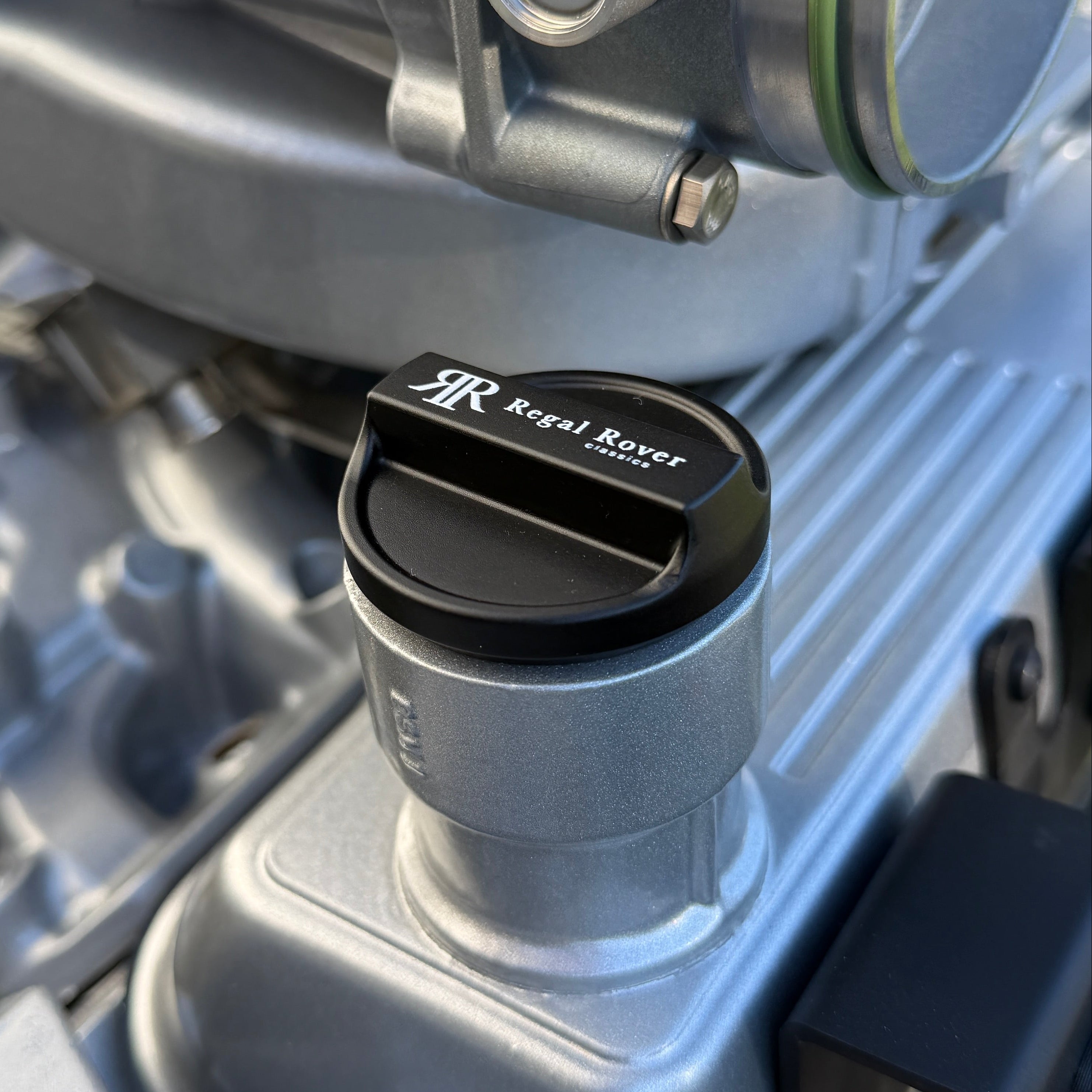 Close-up of a mechanical component with a brand logo on a vehicle engine.