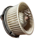 Old used dirty Range Rover Classic blower fan held in a hand with a blurred background